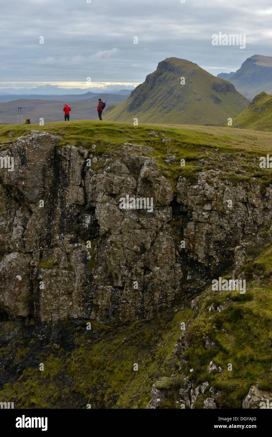 Gli escursionisti in piedi in un paesaggio vulcanico, Loch Leum na Luirginn, Flodigarry, altopiani, Isola di Skye, Scotland, Regno Unito Foto Stock