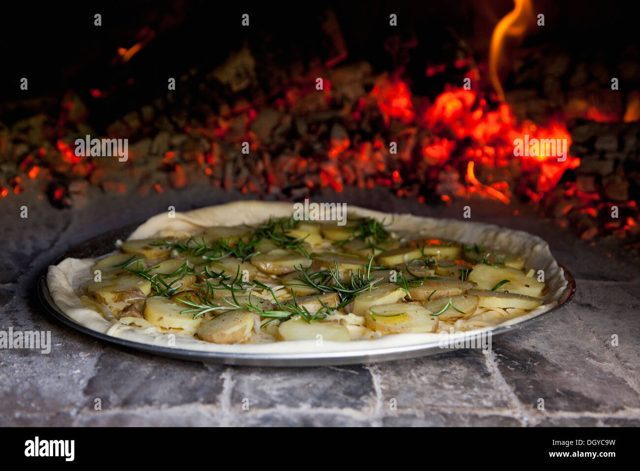 Patate e rosmarino pizza nel forno di mattoni Foto Stock