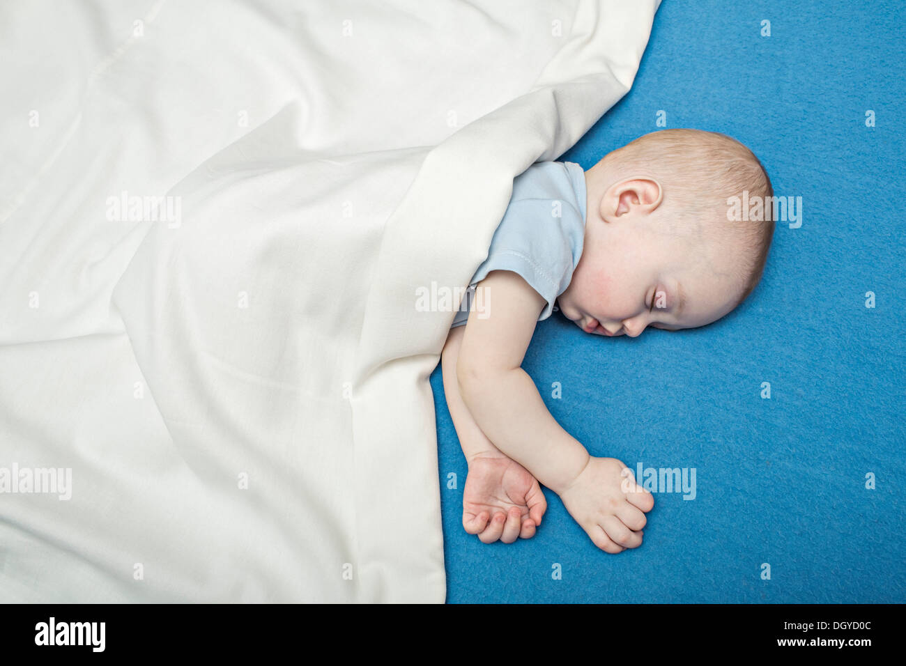 Il bambino dorme sul letto sotto coperta Foto Stock