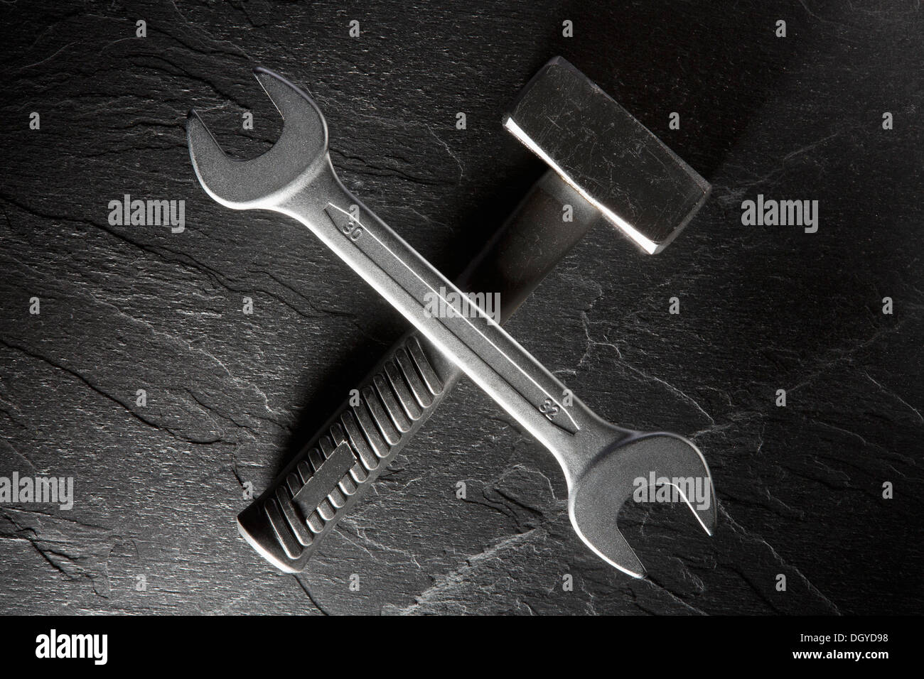 Una chiave in equilibrio su un martello club giacente su un piano del banco in granito Foto Stock