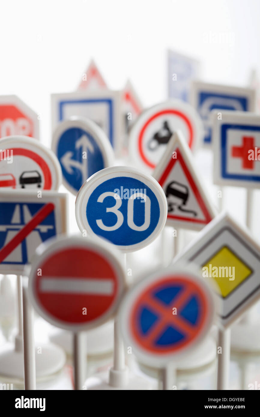 Un giocattolo segnale di limite di velocità è circondato da altri vari road segni di avvertenza Foto Stock