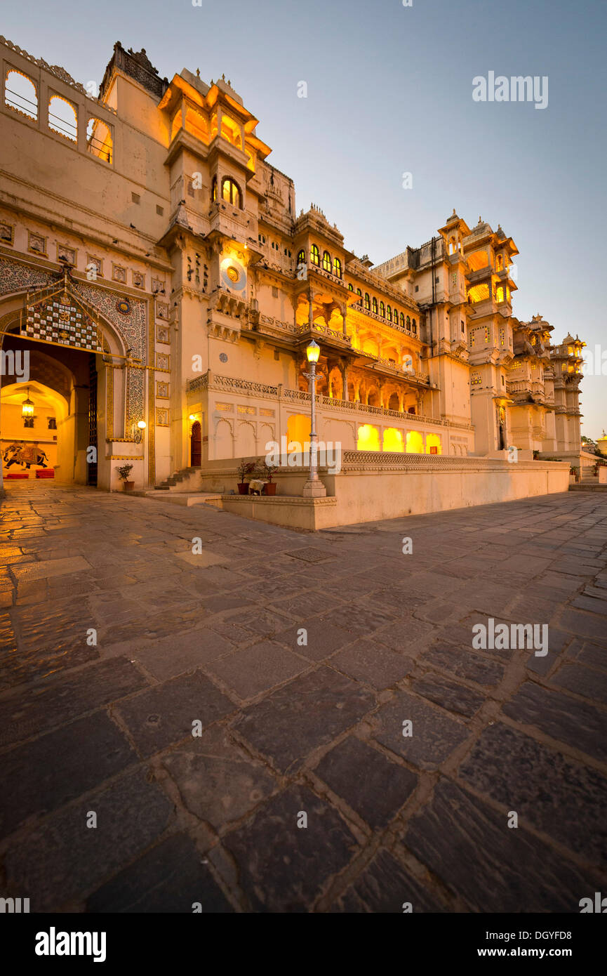 Il cortile e la città illuminata Palazzo del Maharana di Udaipur, Udaipur, Rajasthan, India Foto Stock