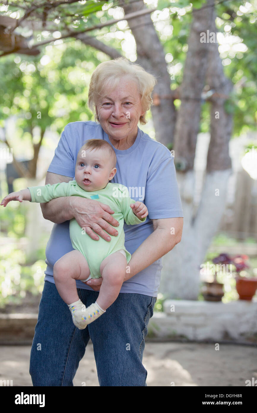 Un allegro nonna tenendo a suo nipote Foto Stock