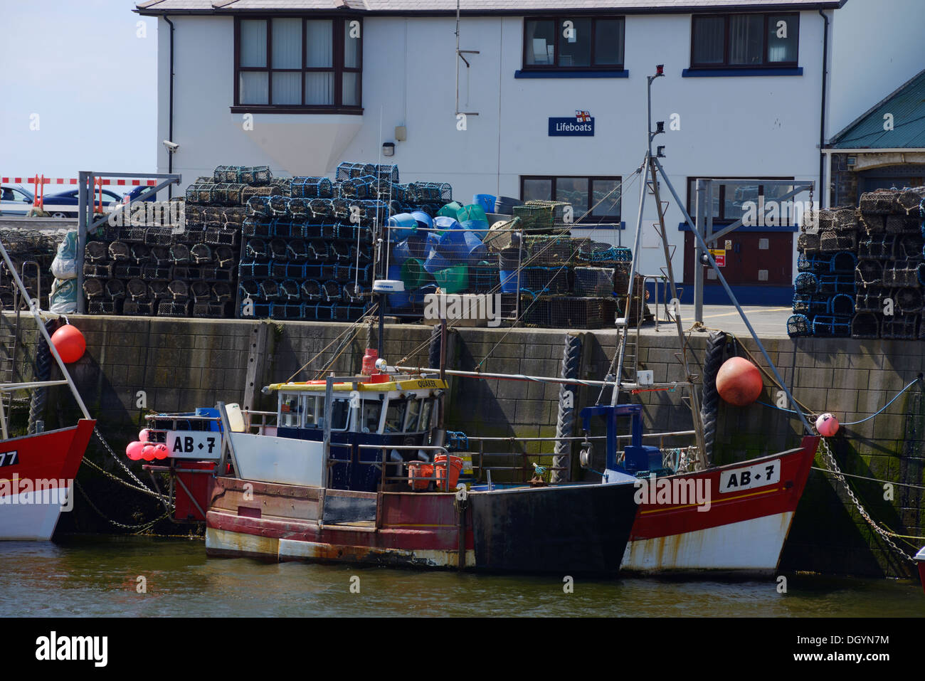 La pesca dell'aragosta barca ormeggiata in banchina con aragosta cantre, pentole in background, Aberystwyth, Wales, Regno Unito Foto Stock