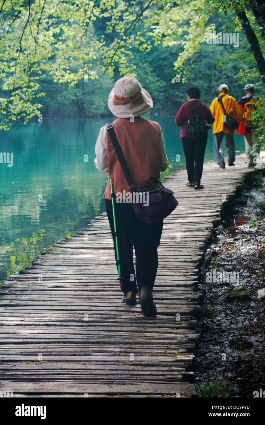 I turisti camminano lungo il sentiero in legno per vedere le cascate e i laghi del Parco Nazionale dei Laghi di Plitvice, patrimonio dell'umanità dell'UNESCO, in Croazia, a maggio Foto Stock