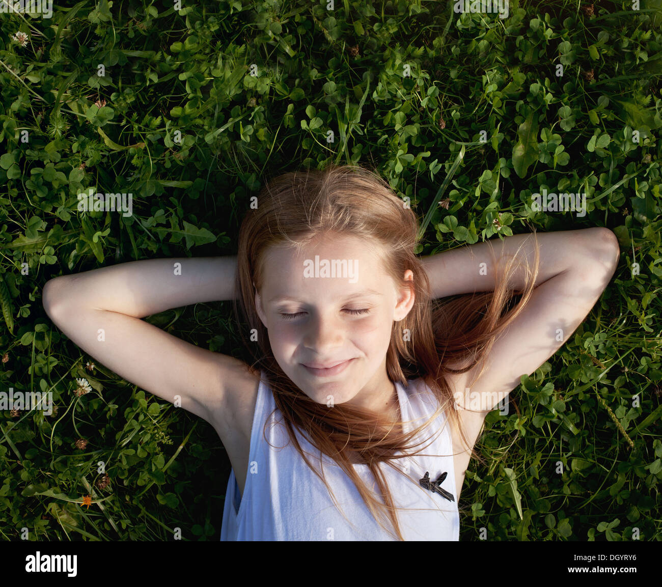 Felice bambina dreaming sull'erba e godendo di estate Foto Stock