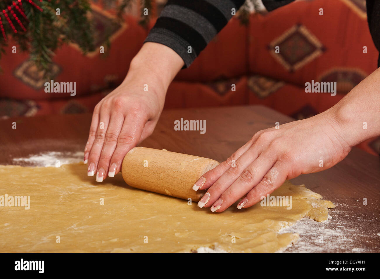 Donna di mani di pasta di laminazione con un mattarello Foto Stock
