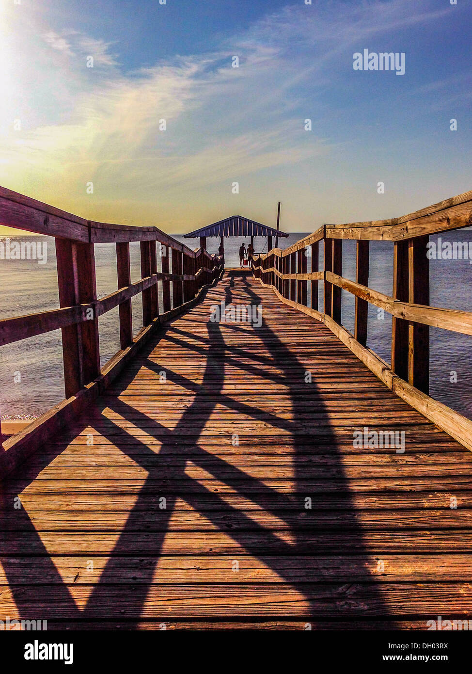 Le ombre della ringhiera sul dock di legno al tramonto - Immagine stock catturata con smartphone