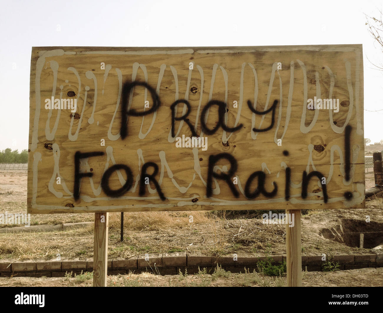 Pregare per avere la pioggia! Verniciato a spruzzo sul tabellone vuoto Foto Stock