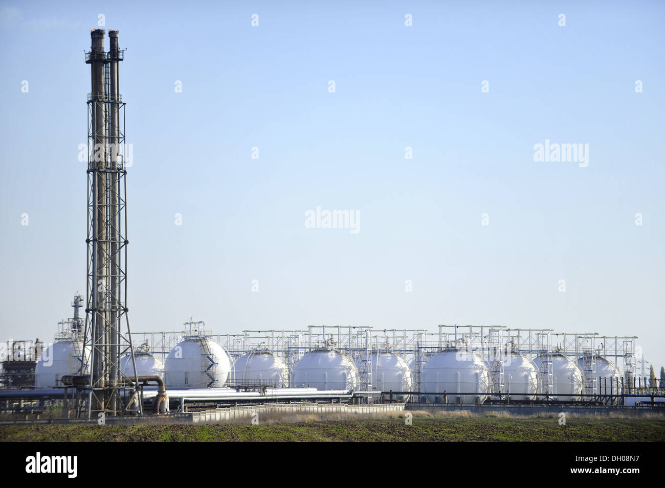 Gas a serbatoi di stoccaggio in impianto petrolchimico con cielo chiaro su sfondo Foto Stock
