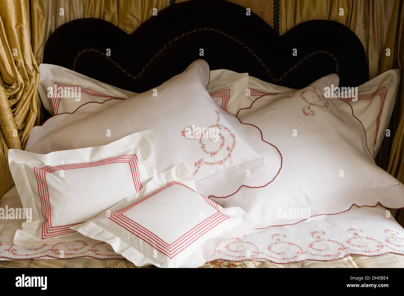 Rosso e rosa su ricamato bianco percalle cuscini e guanciali Foto Stock