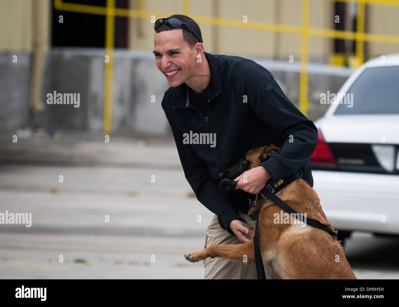 Il personale Sgt. Jonathan Calo, 628th delle forze di sicurezza K9 Il gestore, e il suo cane Ttilley, giocare al di fuori di un magazzino 22 Ottobre 2013 prima di un rilevamento di esplosivi di formazione in Summerville, S.C. Durante questo corso di formazione, i cani vengono sottoposti a ostacoli dove hanno cercato di t Foto Stock
