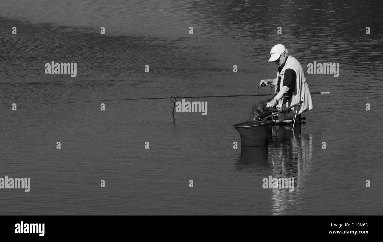 Uomo di pesca in acque di grande riserva naturale, Newcastle upon Tyne Foto Stock