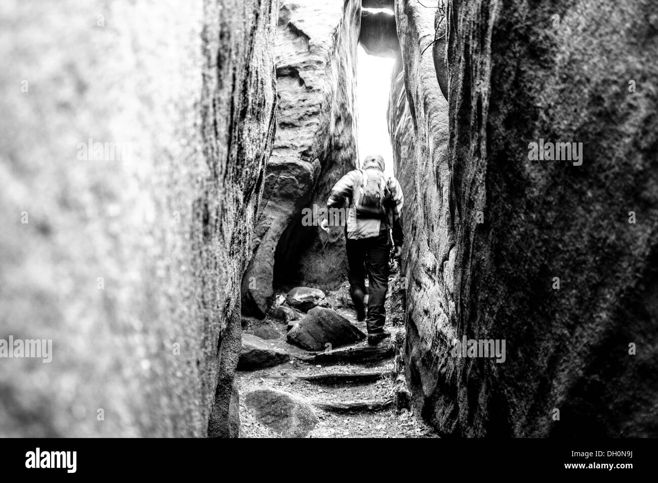 Un uomo è in esecuzione attraverso la sabbia rocce. REPUBBLICA CECA Foto Stock