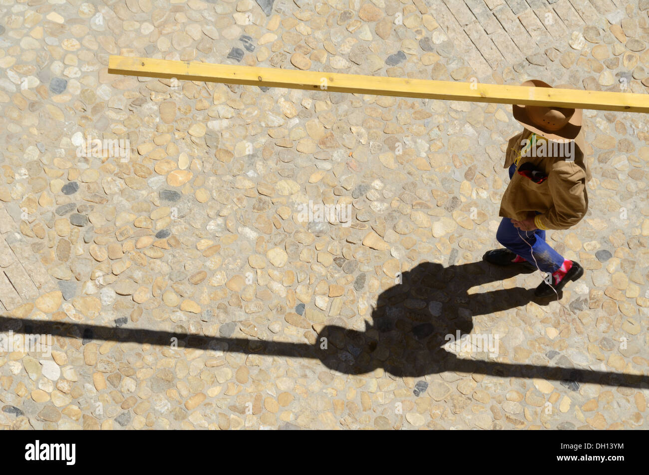 Man Balancing Plank su testa, testa Che Trasporta, o Che Trasporta Pesante Peso o legno sulla testa Foto Stock