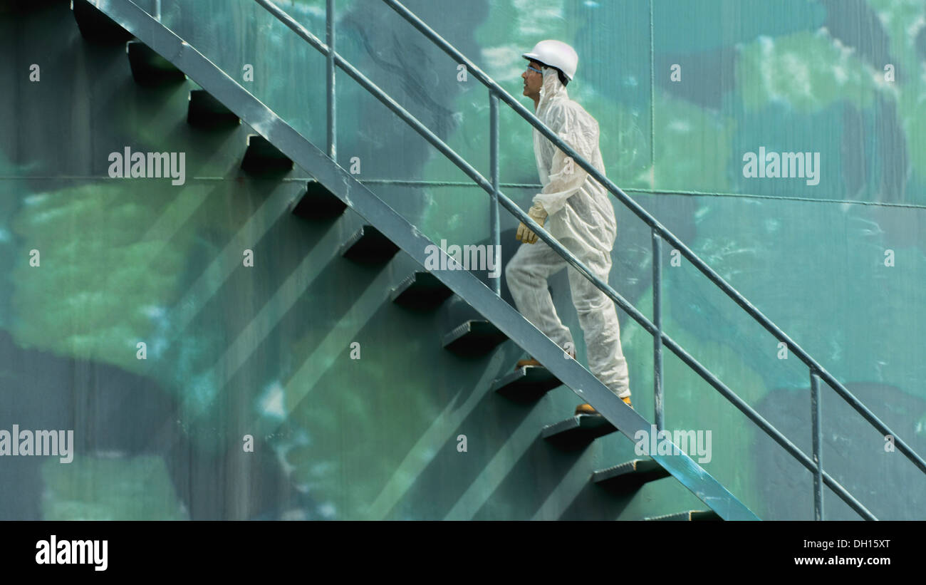 Lavoratore ispanica climbing water tower Foto Stock