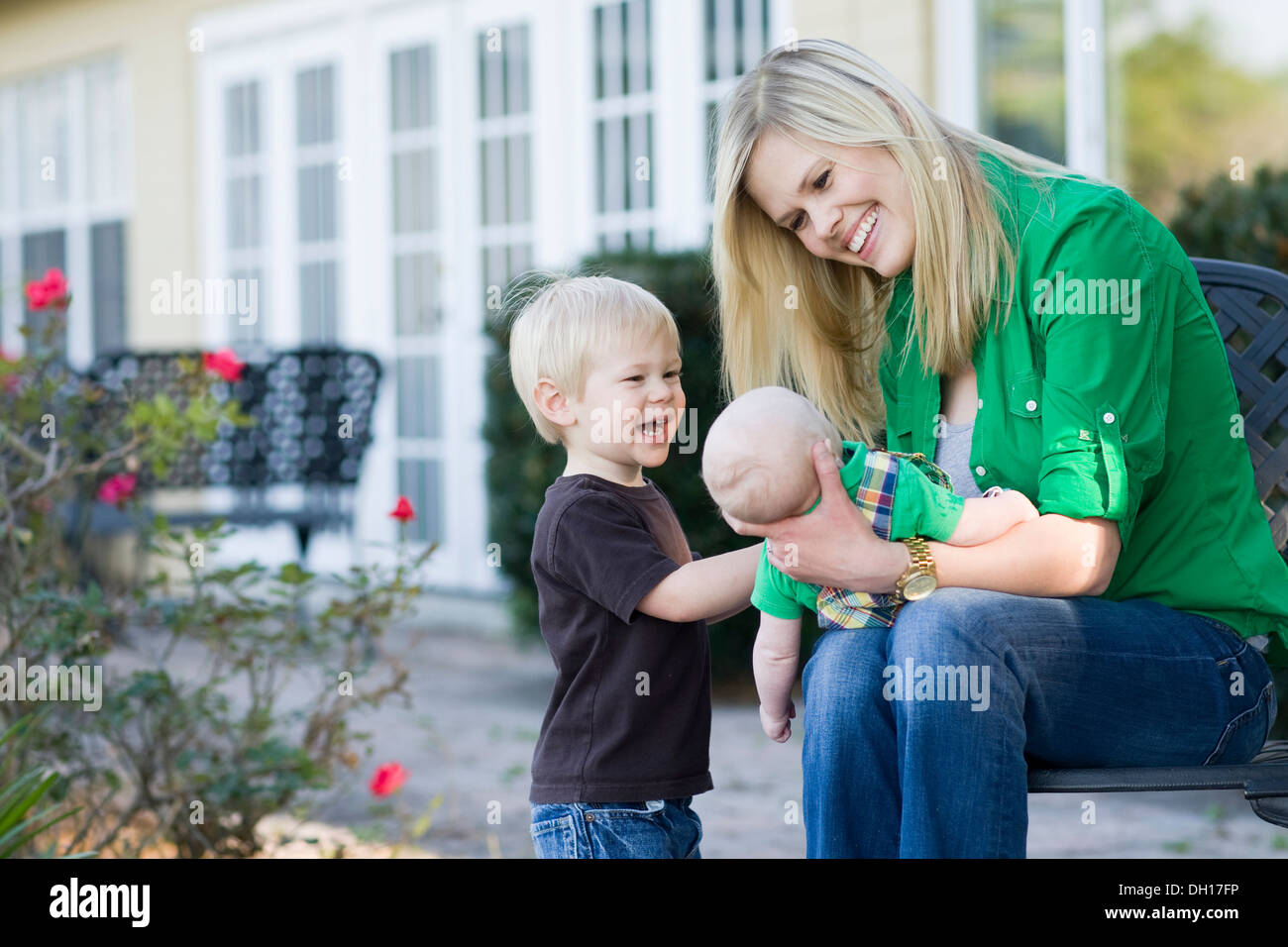 Madre caucasica rilassante con i bambini in giardino Foto Stock
