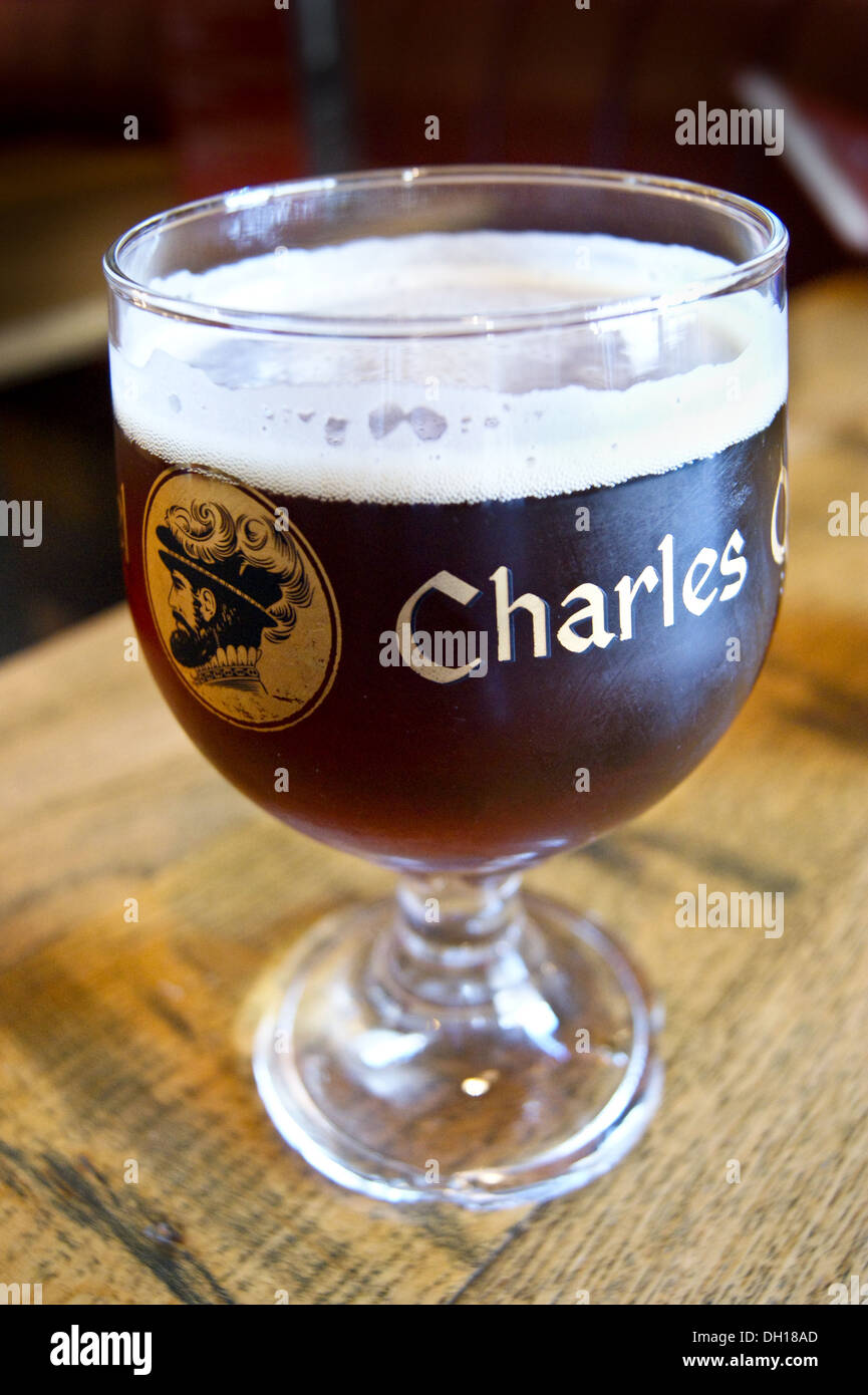 Un vetro stampato di Keizer Karel (Charles Quint) ruby birra su un bar cafe di Ypres, Ieper, Belgio Foto Stock