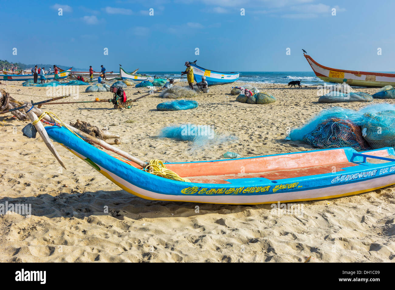 I pescatori locali preparano le loro reti e barche sulla spiaggia di sabbia in una mattina di sole a Mamallapuram, Tamil Nadu, India. Foto Stock