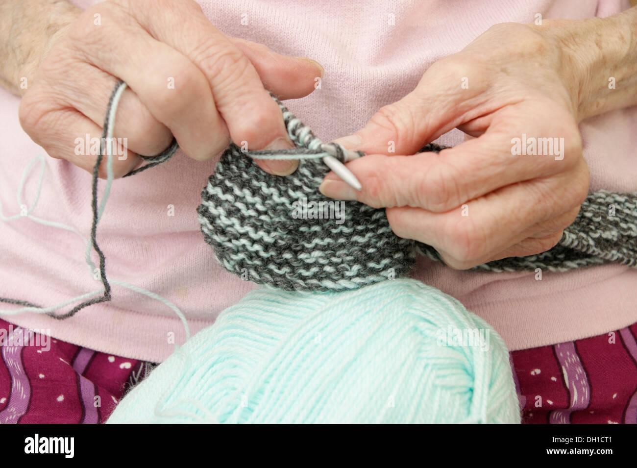 Donna anziana la tessitura di un indumento di maglieria - non è solo un grande hobby / interesse ma aiuta a mantenere il cervello attivo. Questo pensionato ha un cattivo arthritiritis Foto Stock