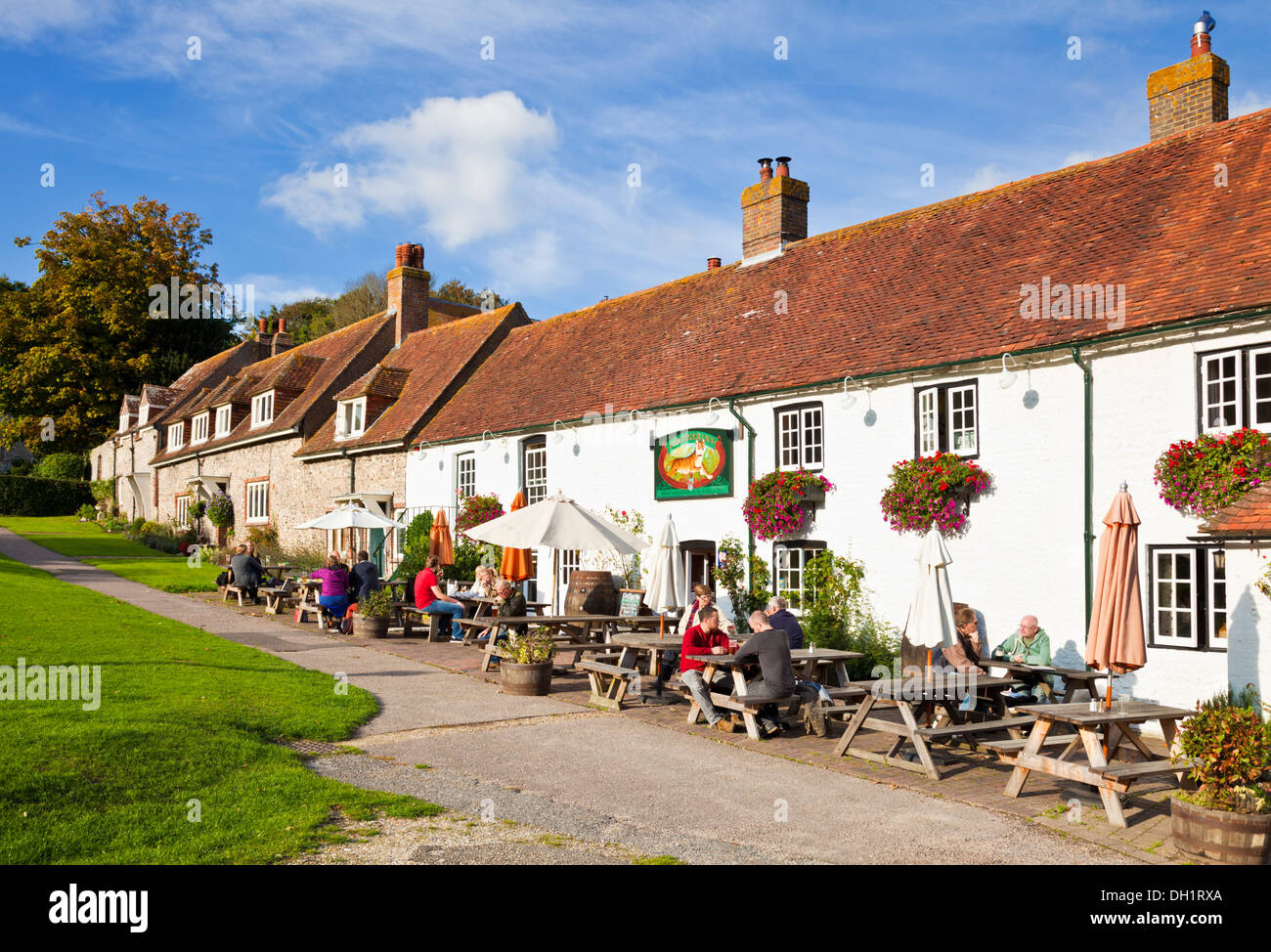 La gente seduta fuori la tigre Inn sul verde villaggio est Dean East Sussex England Regno Unito GB EU Europe Foto Stock