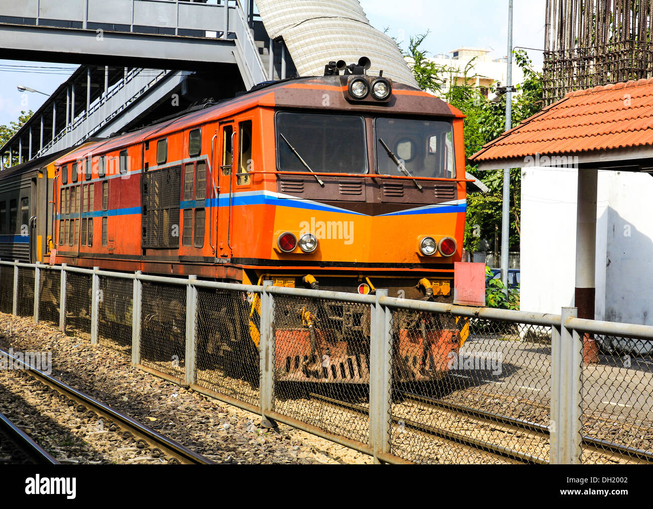 Rosso arancione treno, locomotive diesel, su Bangkok stazione ferroviaria piattaforma Thailandia Foto Stock
