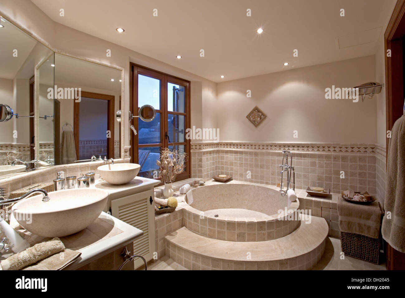 Fase di piastrelle fino a circolare bagno termale nella moderna piastrelle bagno spagnolo circolare con doppia vasca vasche Foto Stock