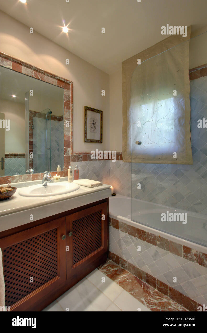 Vetro dello schermo doccia su vasca da bagno in spagnolo moderno bagno con  voile cieco sulla finestra Foto stock - Alamy