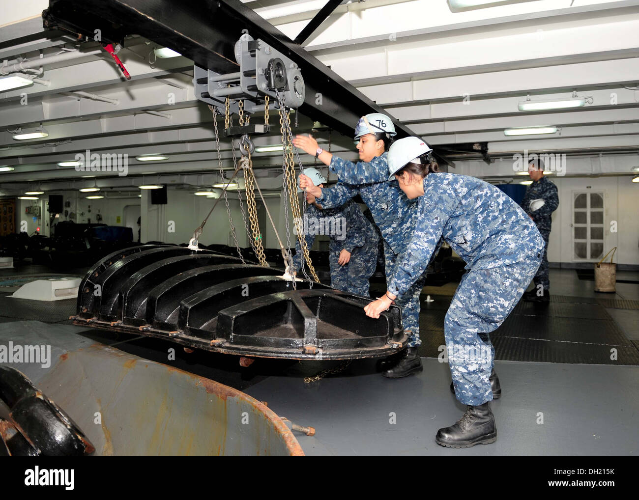 I marinai utilizzare un paranco a catena per spostare un hawse tubo di copertura a bordo della portaerei USS Ronald Reagan (CVN 76). Ronald Reagan è ormeggiata e home-trasferito alla Base Navale di Coronado. Foto Stock