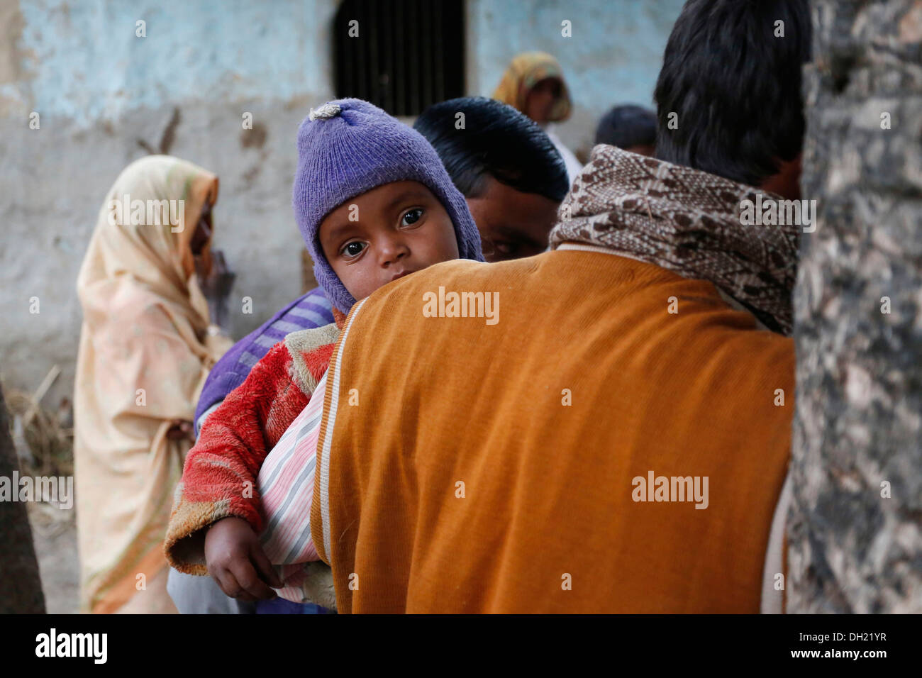 Un giovane bambino sul braccio di suo padre, gli abitanti di un villaggio vicino Rajbiraj, Terai regione, Nepal, Asia Foto Stock