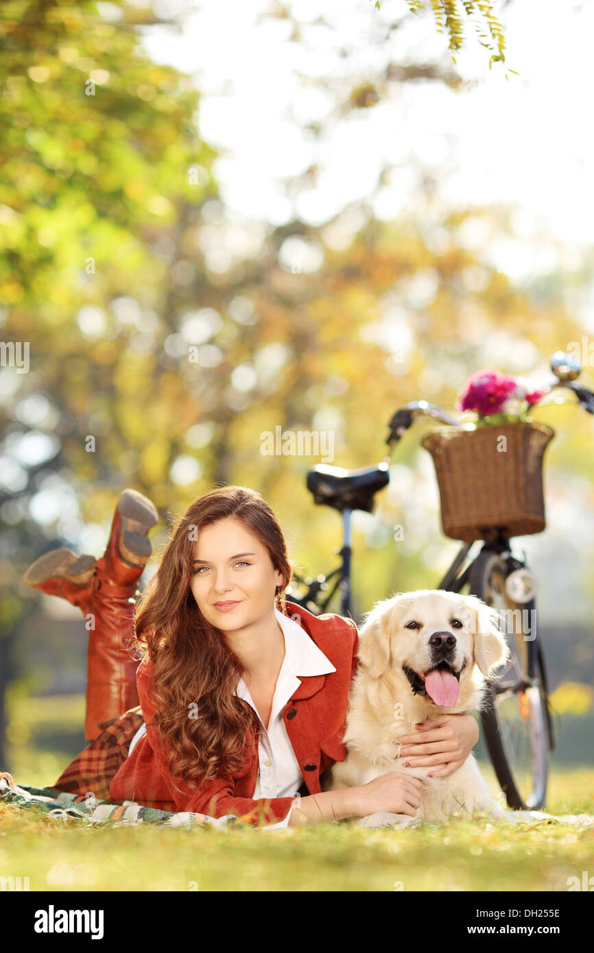 Bellissima femmina sdraiato con il labrador retriever cane in un parco Foto Stock