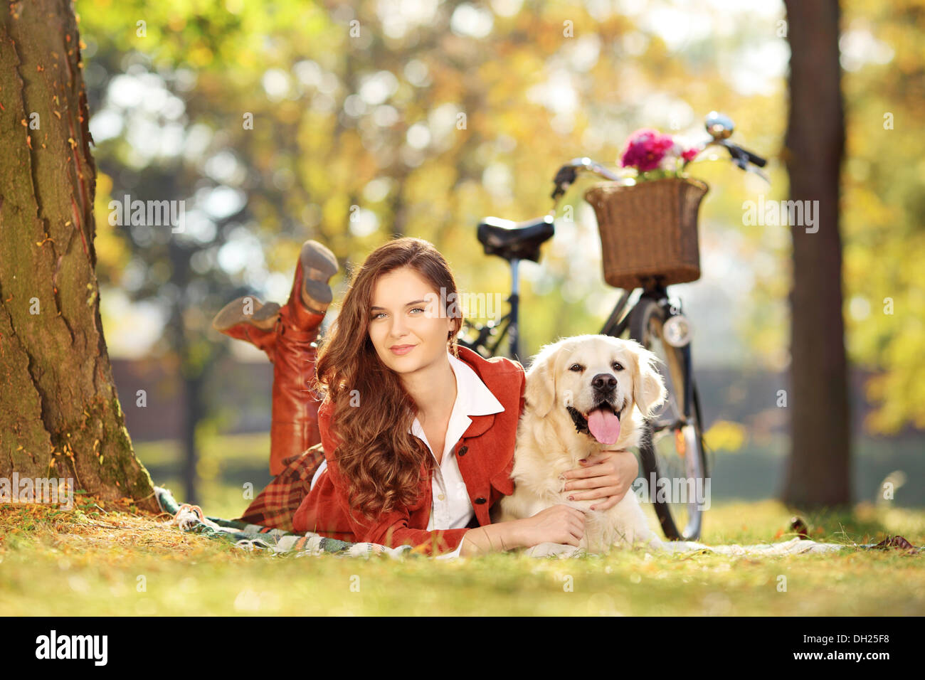 Piuttosto giovane femmina sdraiato con il cane in un parco Foto Stock