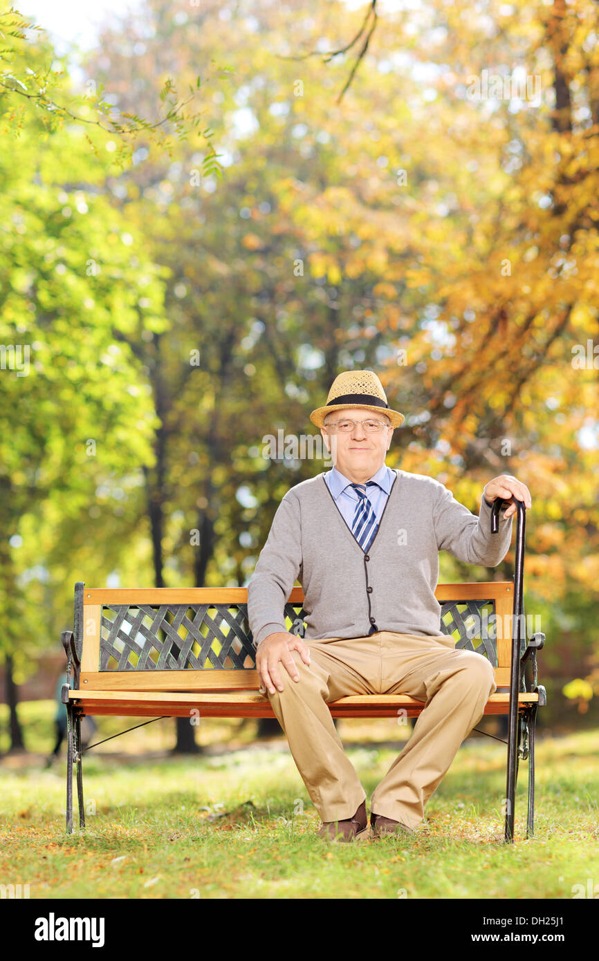 Rilassata senior gentleman seduta su una panchina nel parco Foto Stock