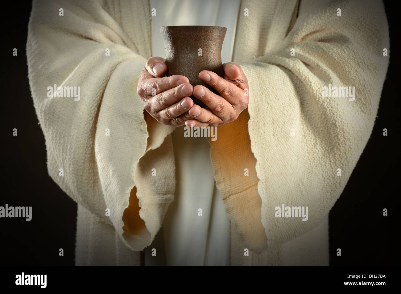 Le mani di Gesù tenendo la coppa di vino, simbolo di comunione Foto Stock