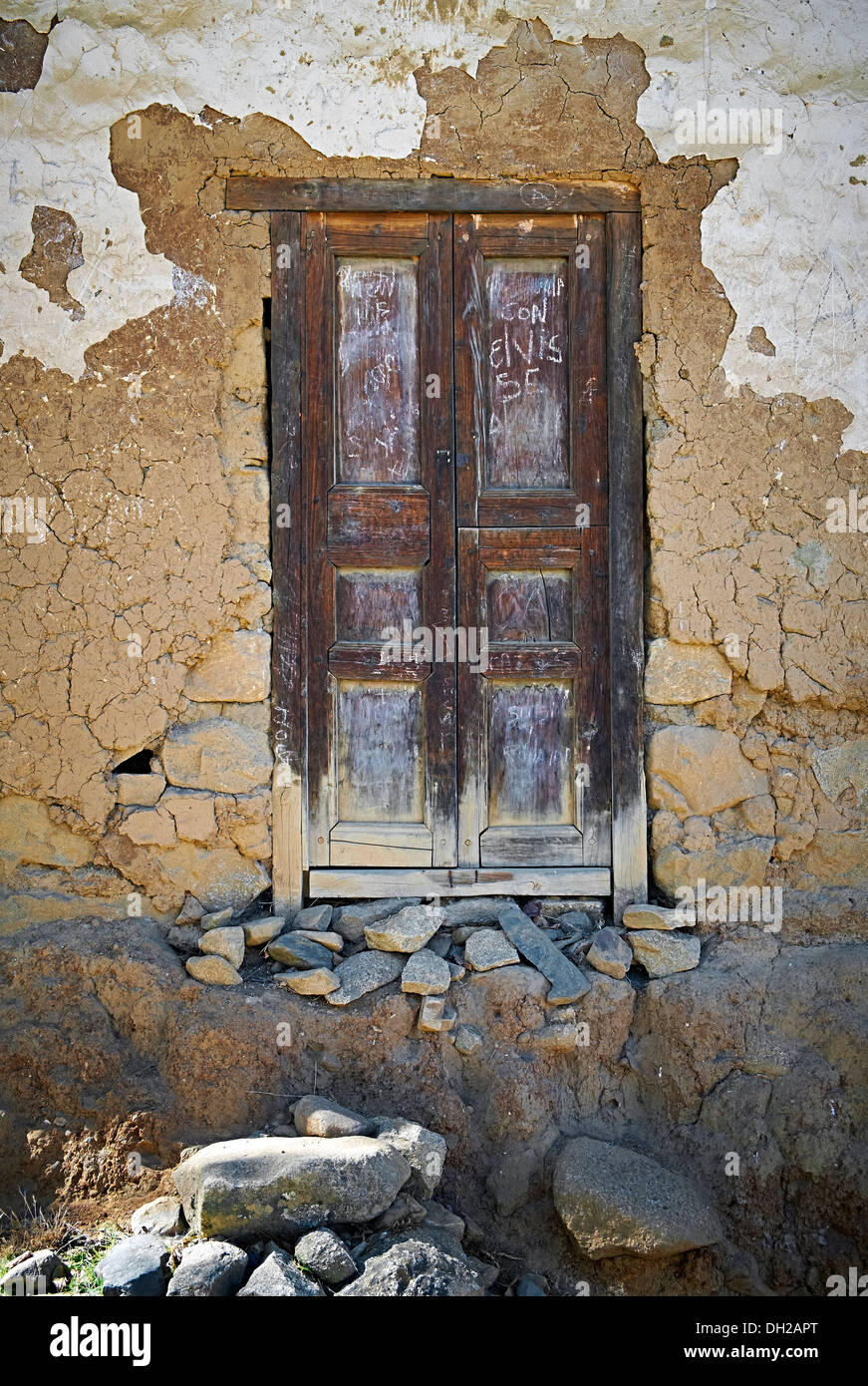 Una vecchia porta di legno su un edificio di adobe nelle Ande peruviane, Sud America. Foto Stock