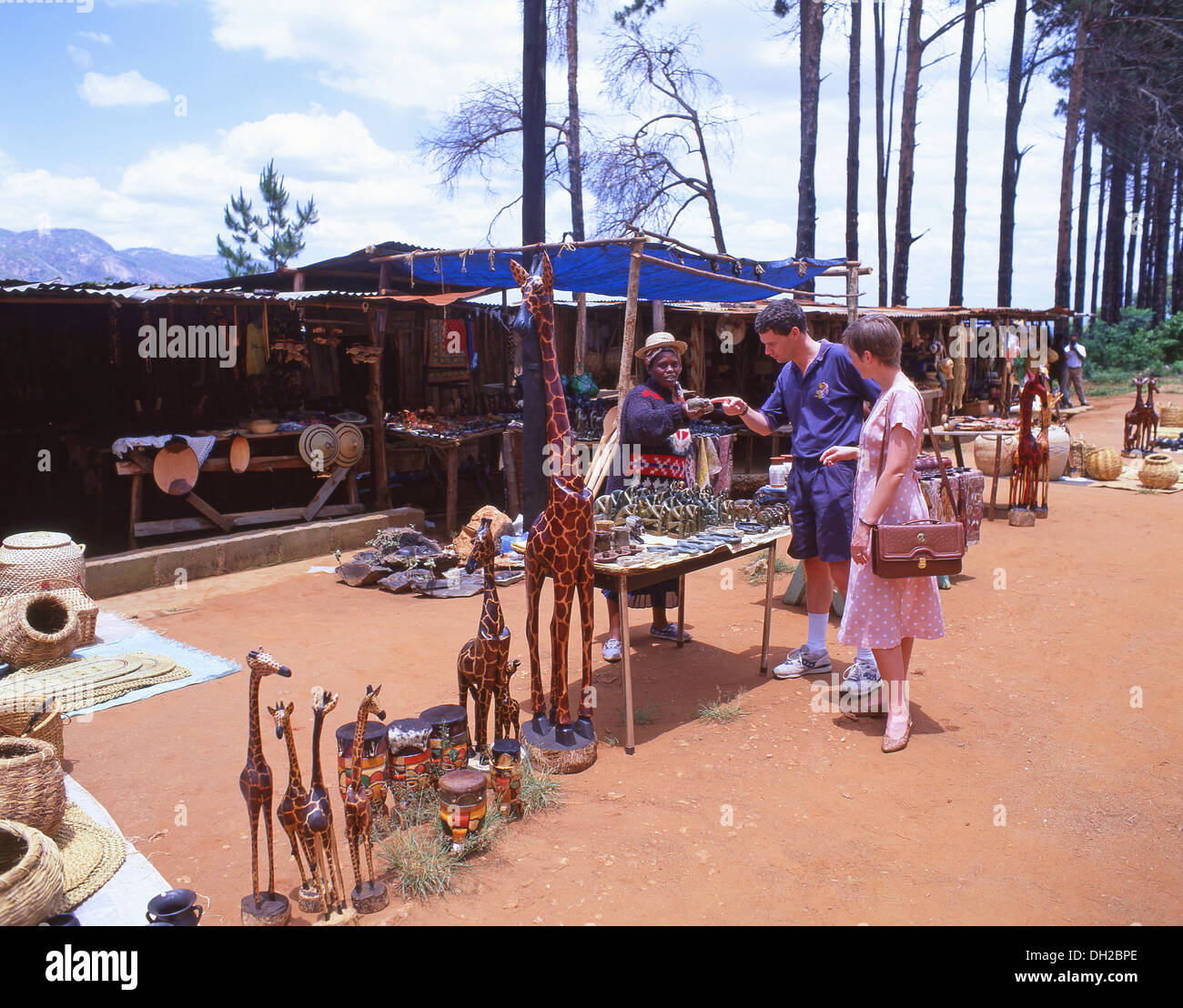 Giovane coppia turistica per lo shopping di souvenir al mercato artigianale stradale, Lubombo District, Eswatini (Swaziland) Foto Stock