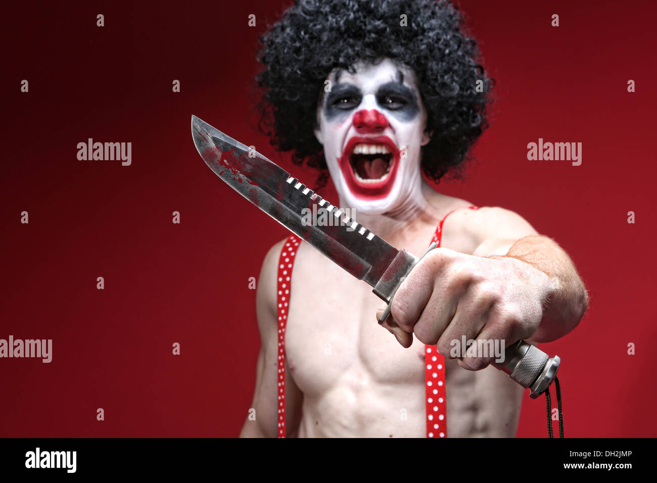 Il male Spooky Clown ritratto tenendo il coltello Foto Stock