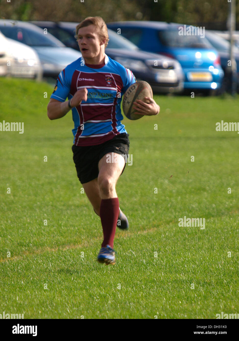 Giocatore di rugby in esecuzione con la palla, Bude, Cornwall, Regno Unito Foto Stock