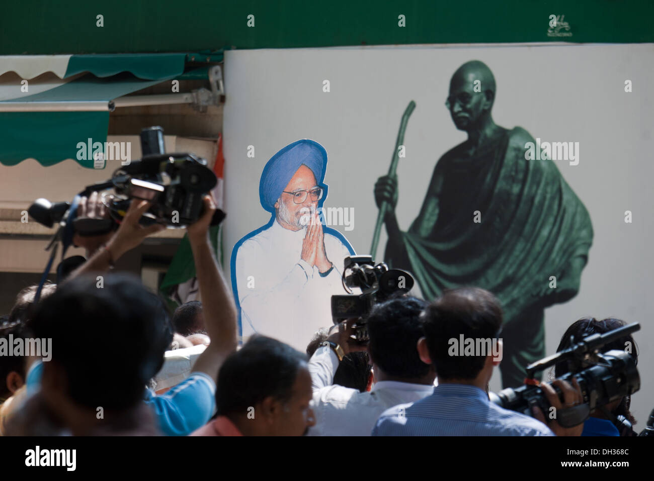 Il Mahatma Gandhi poster e Dr Manmohan Singh tagliati fuori e premere fotografi Maharashtra India Asia Foto Stock