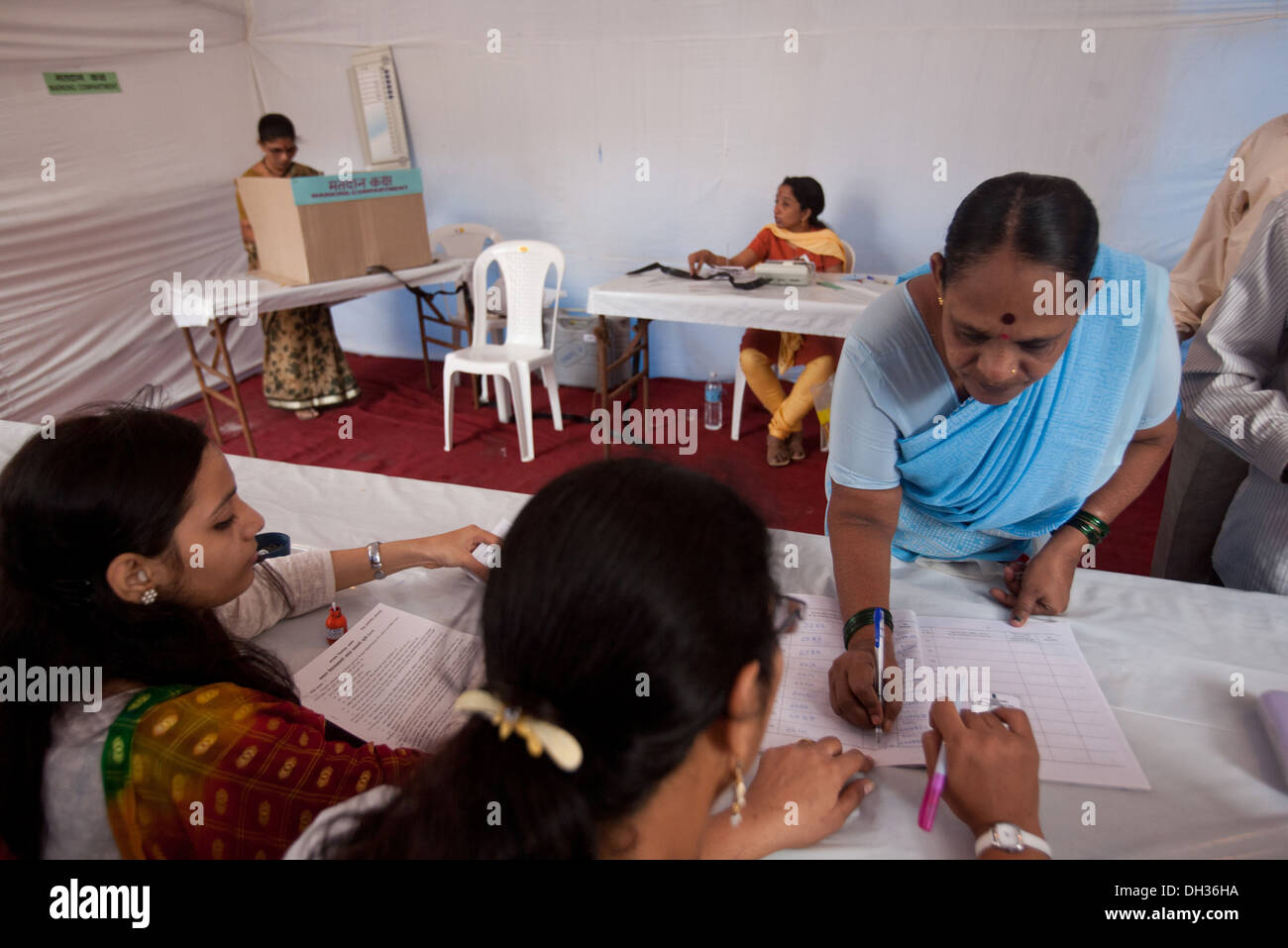 La firma degli elettori a prova di identità prima di votare alle elezioni Maharashtra India Asia Foto Stock