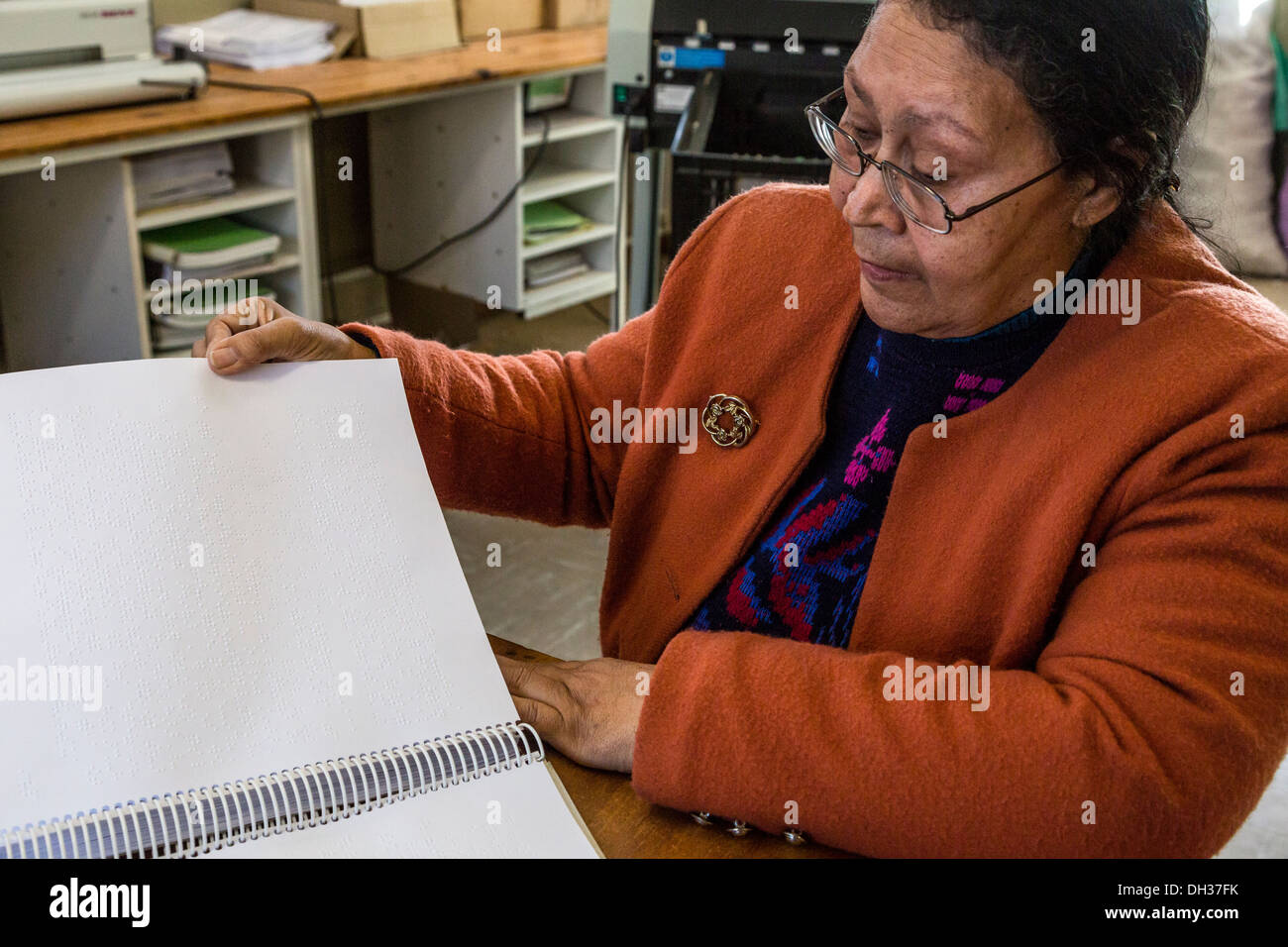 Sud Africa, Cape Town. Editor Braille esaminando le cartelle di lavoro stampate per gli studenti. Athlone scuola per ciechi. Foto Stock