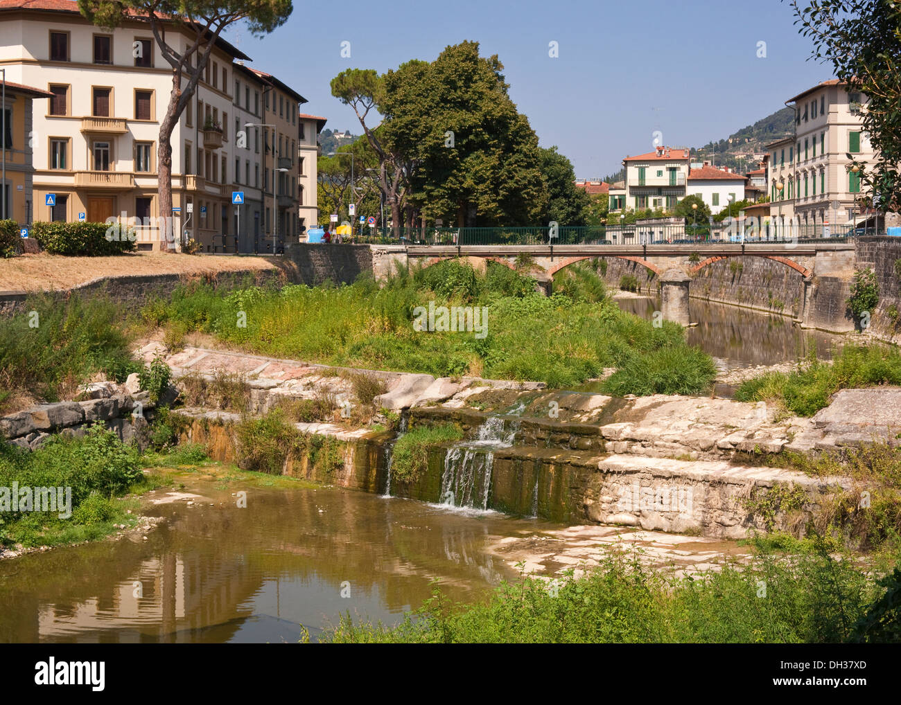 Un incolto weir e riverbank a Firenze, Italia Foto Stock