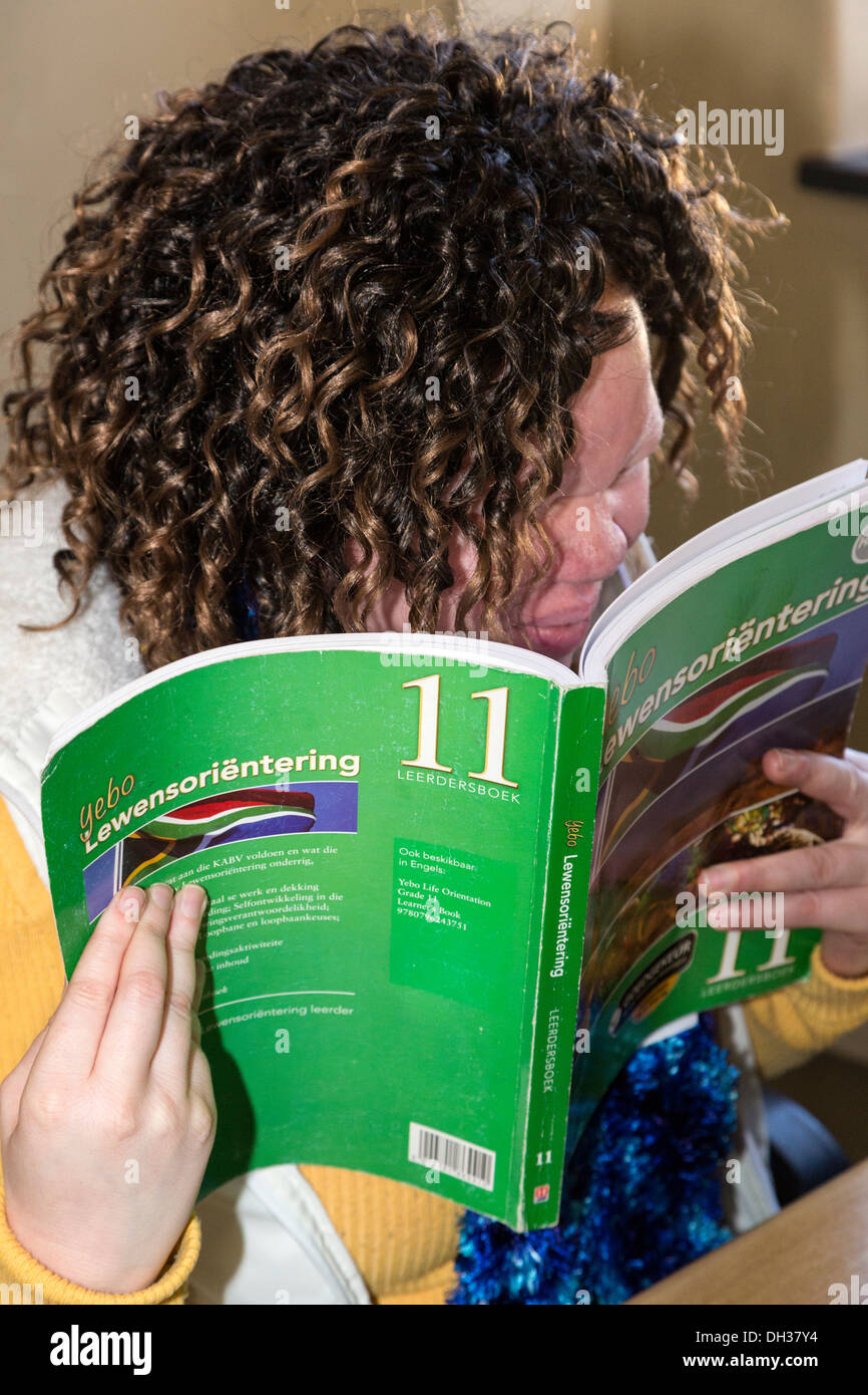 Sud Africa, Cape Town. Ipovedenti Albino studente eserciziario di lettura. Athlone scuola per ciechi. Foto Stock