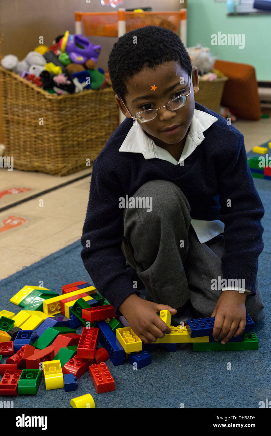 Sud Africa, Cape Town. Un ipovedenti giovane ragazzo assembla pezzi di Lego da toccare. Athlone scuola per ciechi. Foto Stock