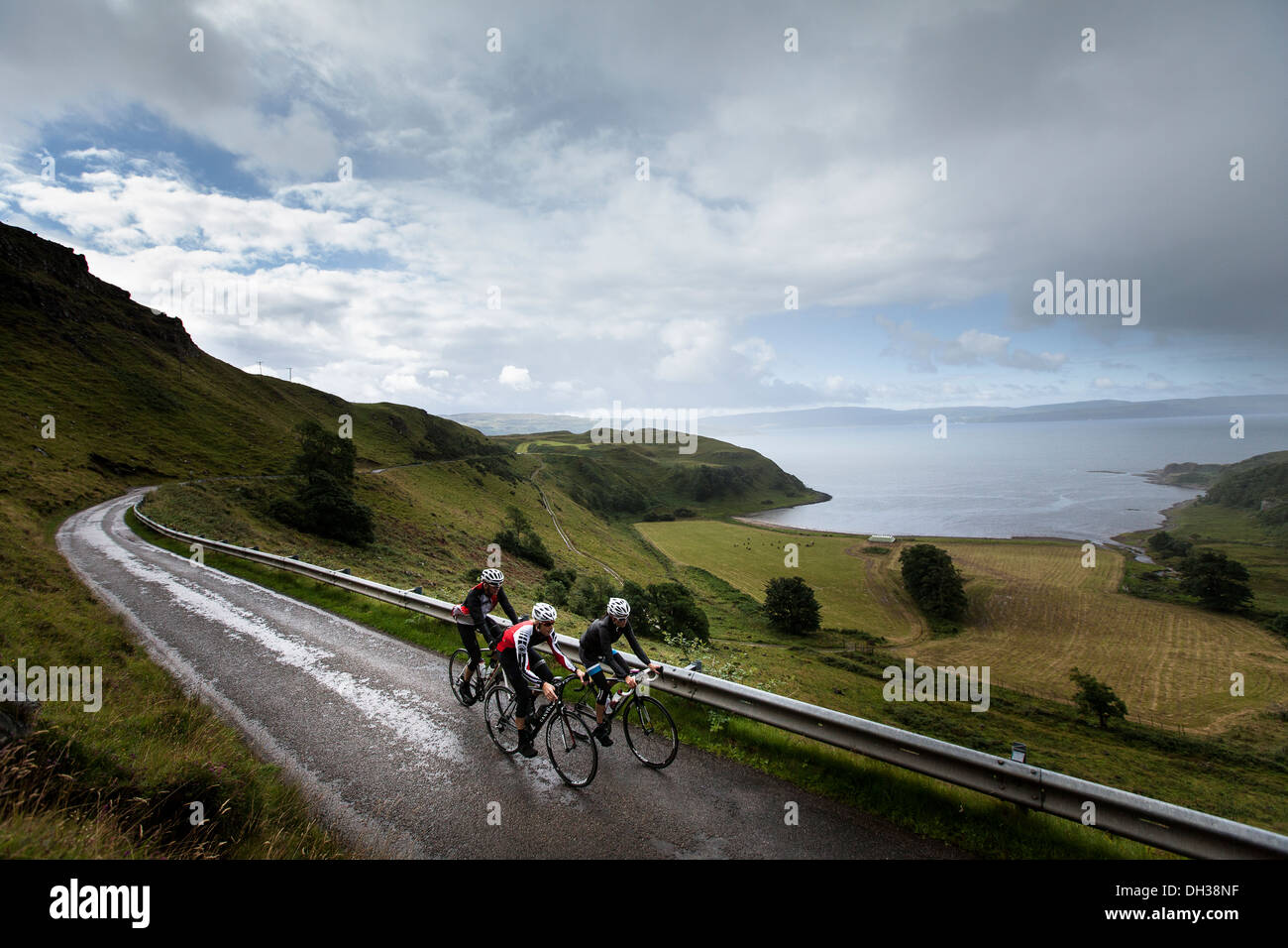 Tre i ciclisti cavalcare un percorso umido nelle Highlands scozzesi, Scotland, Regno Unito Foto Stock