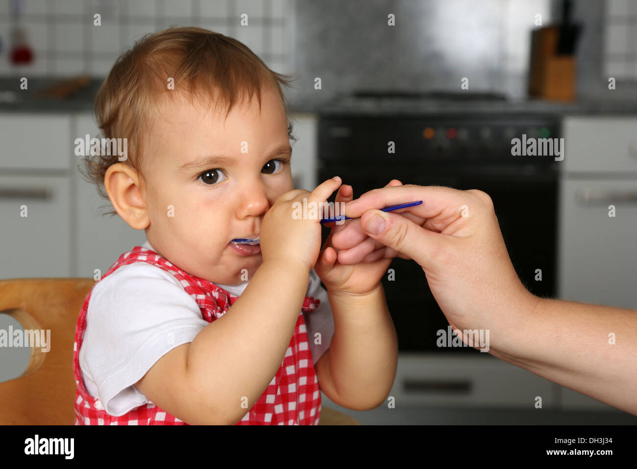 Little Baby girl è affamato, madre sua alimentazione Foto Stock