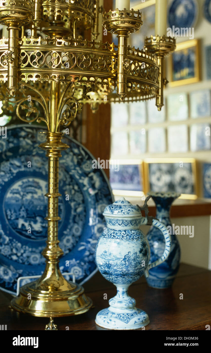 Close-up di ornati in ottone, stile ecclesiastica portacandele con blue+pentole di bianco e la piastra Foto Stock