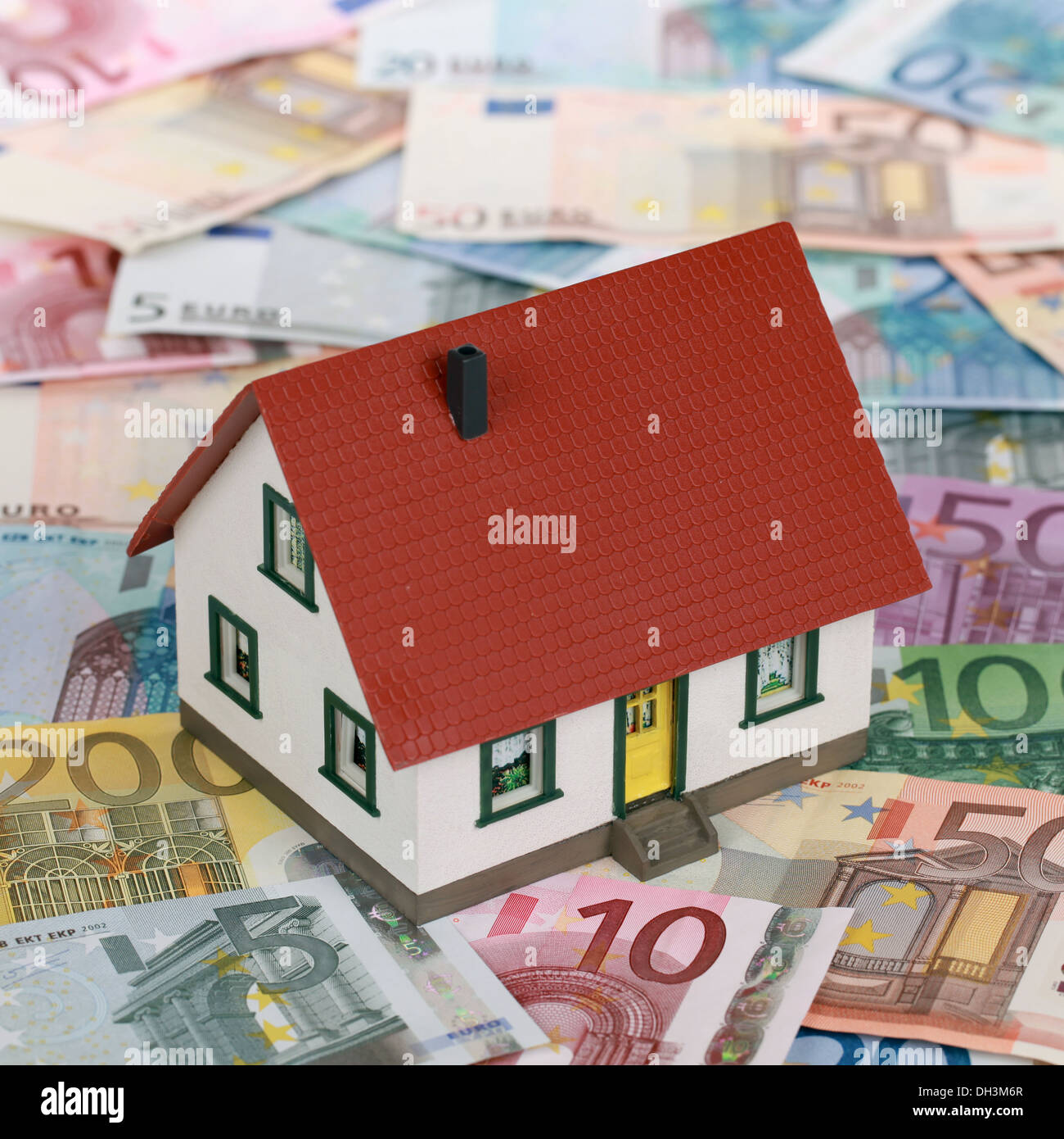 Immagine simbolica di un finanziamento immobiliare con una casa sulle banconote Foto Stock