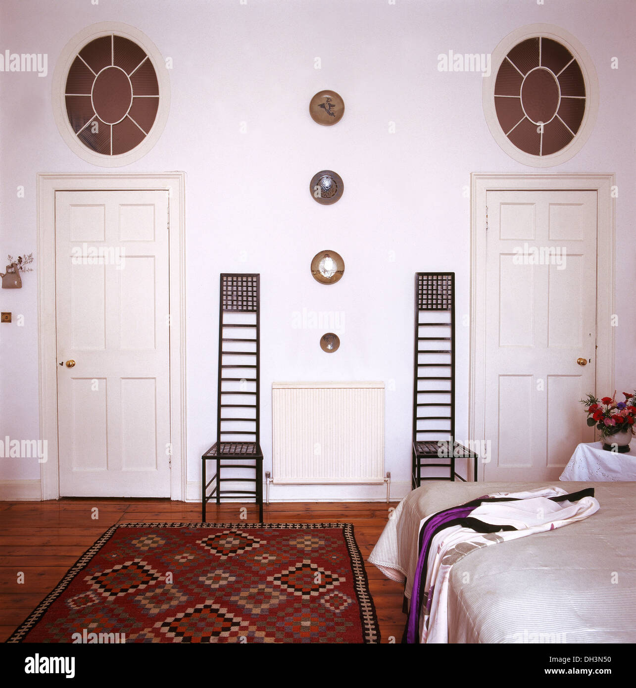 Charles Rennie Mackintosh sedie in camera da letto bianca con tappeto a motivi geometrici in Hill House in Glasgow Foto Stock