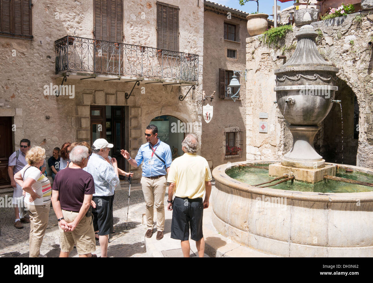 Una guida turistica a parlare con i turisti a La Place de la Grande Fontaine, St Paul de Vence, Francia, Europa Foto Stock
